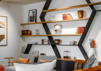 a living room with a black shelving unit with shelves and a couch