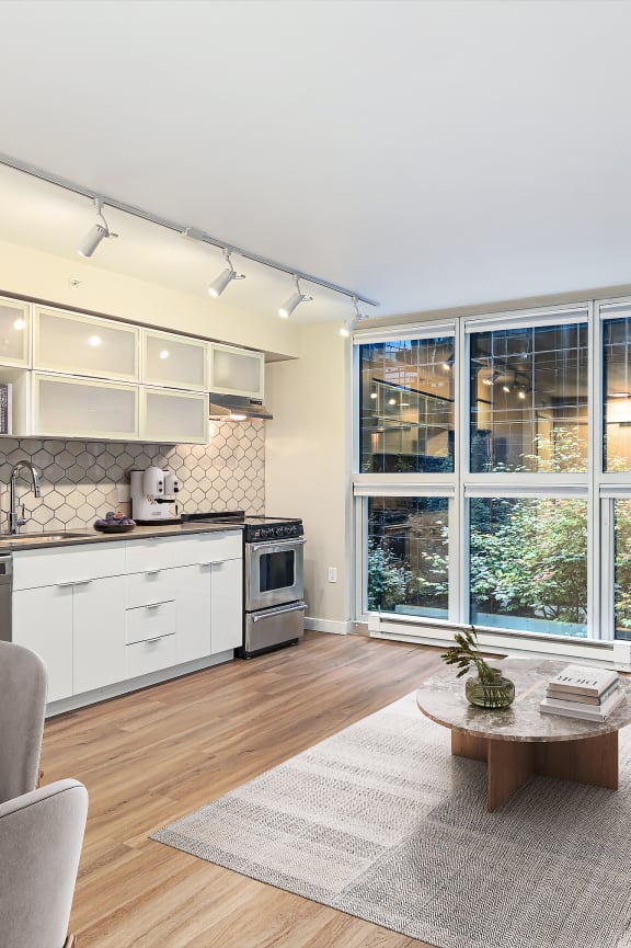a living room with a kitchen and a large window
