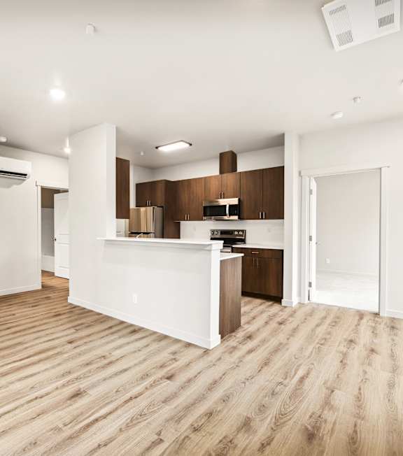 A kitchen with wooden cabinets and a stainless steel refrigerator.