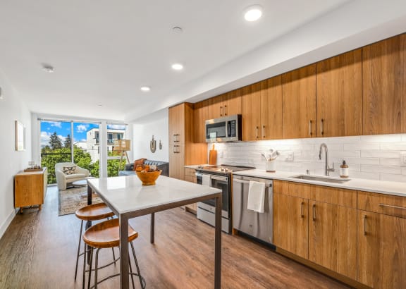 a kitchen with wooden cabinets and a table with three stools