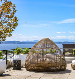 a rooftop patio with couches and chairs and a firepit