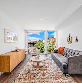 a living room with a couch and a rug and sliding glass doors