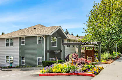A building with a sign that says Woodcreek in front of it.