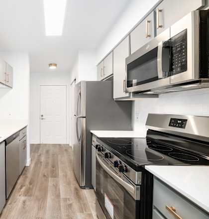 a modern kitchen with white counter tops and stainless steel appliances