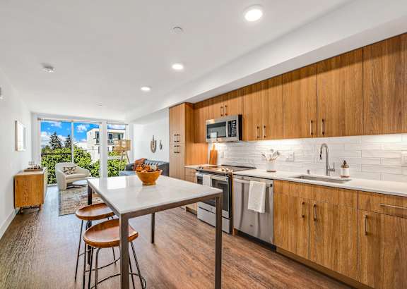 a kitchen with wooden cabinets and a table with three stools