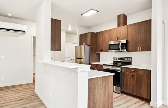 A modern kitchen with wooden cabinets and stainless steel appliances.