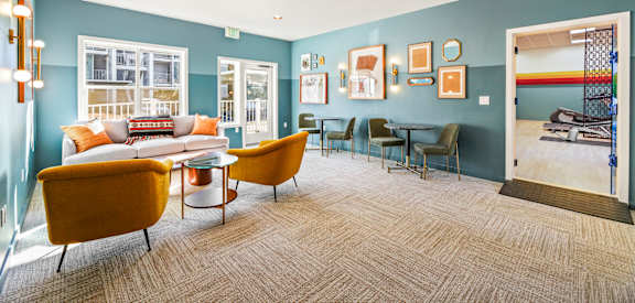 A living room with a yellow chair and a blue wall.