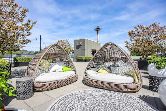 two egg shaped chairs with pillows on a rooftop patio
