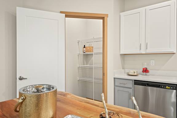 A kitchen with a white door, a white fridge, and a white counter.