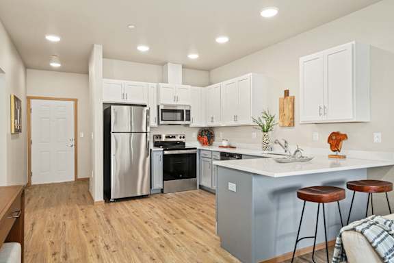 a renovated kitchen with white cabinets and stainless steel appliances