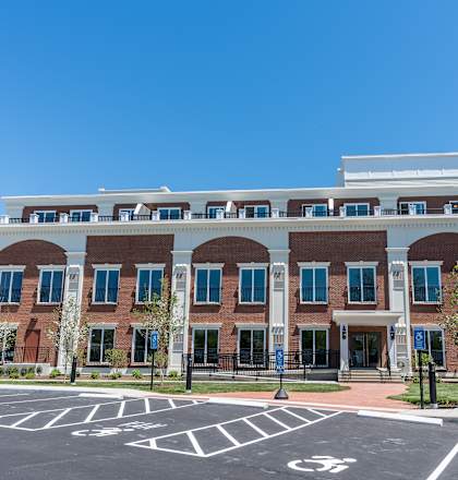 a large brick building with a parking lot in front of it
