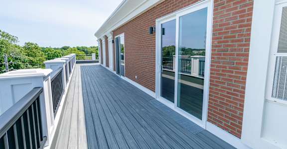 a large balcony with a door that leads into the living room