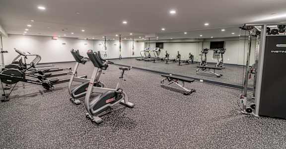a large fitness room with treadmills and other exercise equipment