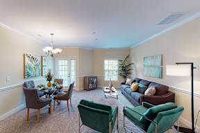 A living room with a dining table and chairs.