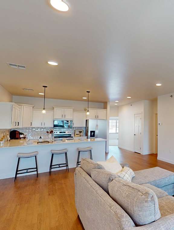 A modern kitchen with white cabinets and stainless steel appliances.