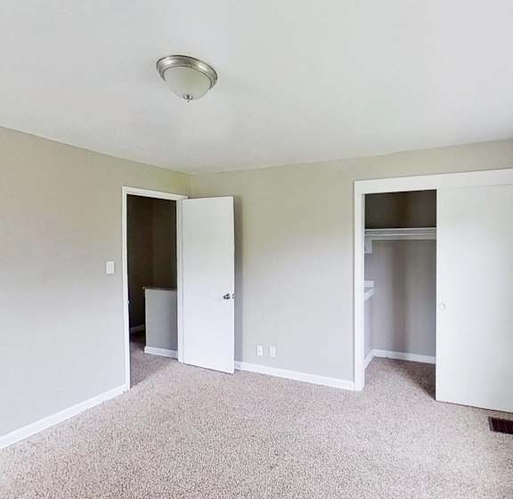 an empty living room with white walls and a window