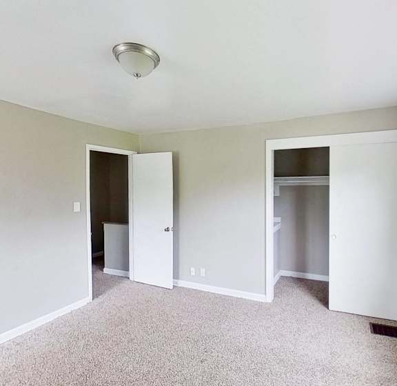 an empty living room with white walls and a window