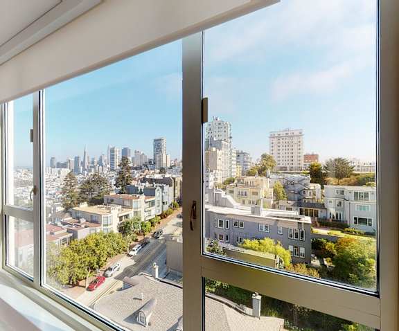 a bedroom with a large window and a city view