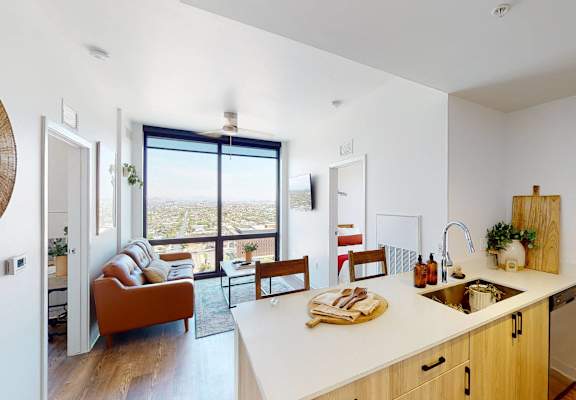 A kitchen with a white countertop and wooden cabinets.