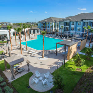 A large swimming pool surrounded by lounge chairs and umbrellas.