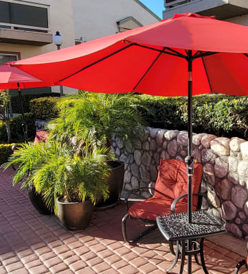 a patio with two chairs and an umbrella