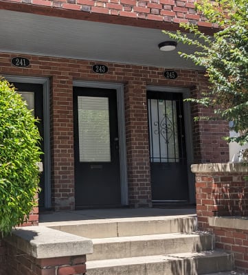 a red brick building with black doors and a black awning