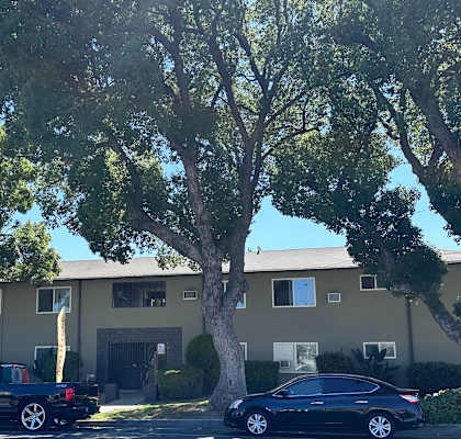 a picture of an apartment complex with cars parked in front of it