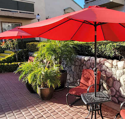 a patio with two chairs and an umbrella