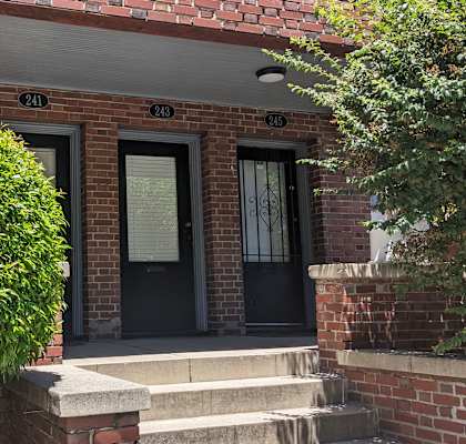 a red brick building with black doors and a black awning