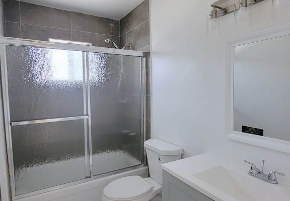 A white toilet sits next to a sink in a bathroom.