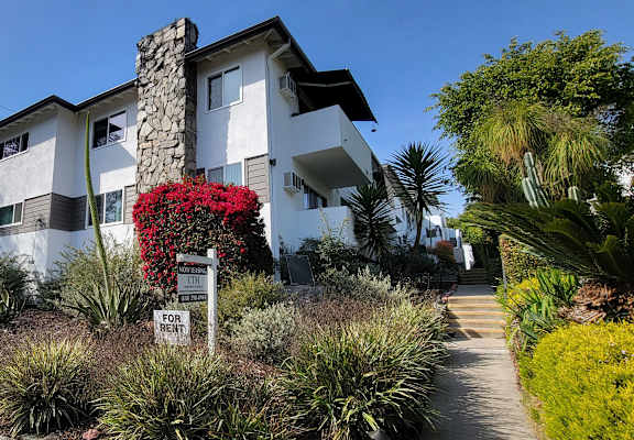 A house with a stone chimney is for rent.