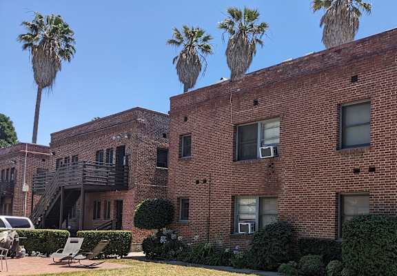 a red brick building with palm trees on top of it