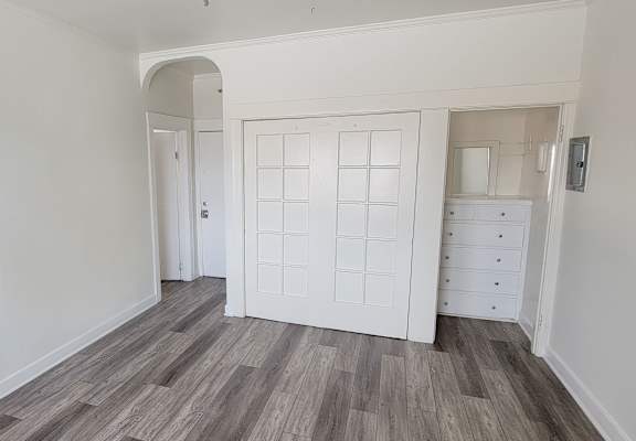 A room with a white door and a white wardrobe.