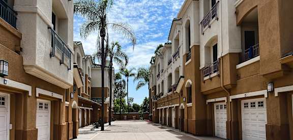 a city street with palm trees and apartment buildings
