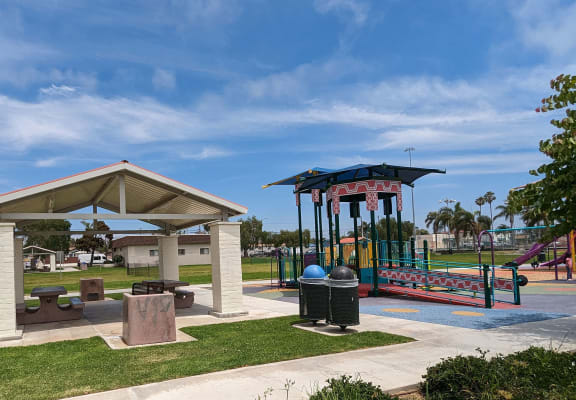 a playground with a gazebo and picnic table