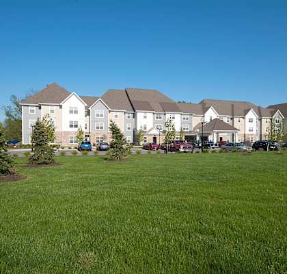 A large white building with a green lawn in front.