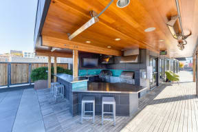 Rooftop BBQ Area with Grills, Mounted Flat Screen Television, Green Chairs, Bar Stool Seating