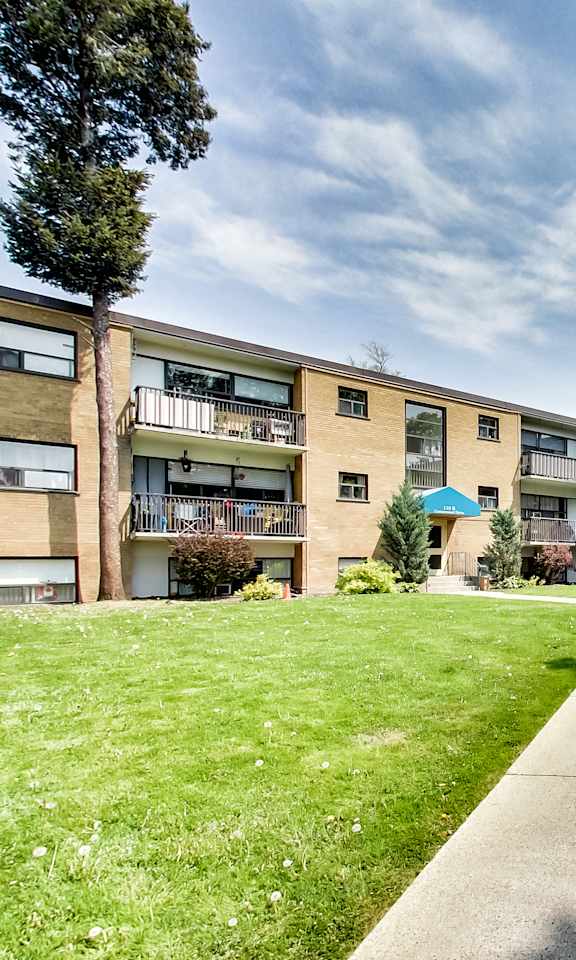 A grassy area in front of apartment buildings.
