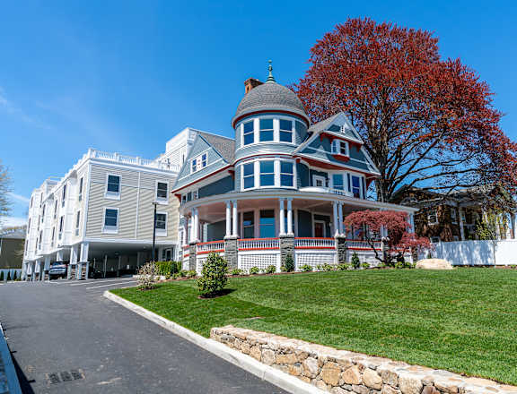 a large house on a hill with a tree in the background