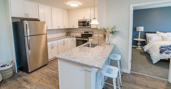 a kitchen with a large island and stainless steel appliances