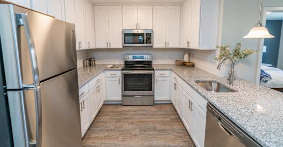 a kitchen with white cabinets and stainless steel appliances