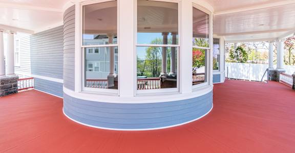 a large circular porch with large windows and a red carpet