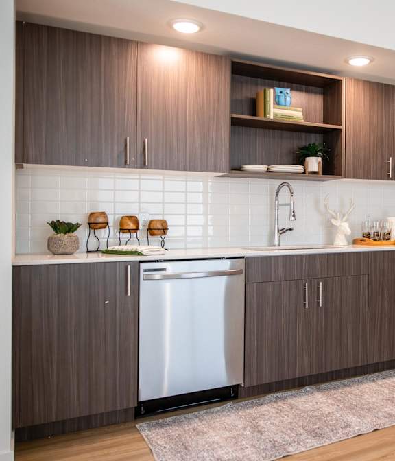 a modern kitchen with dark wood cabinets and white countertops