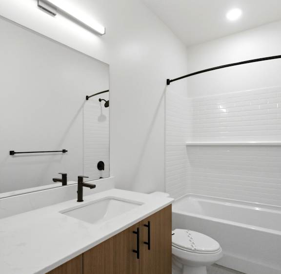 A white bathroom with a toilet, sink, and bathtub.