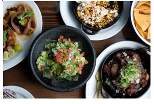 a table topped with plates and bowls of food
