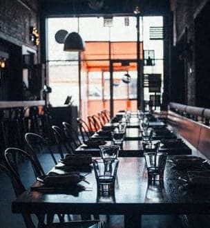 a long table in a restaurant with glasses on it