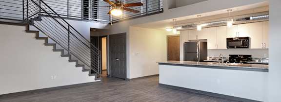 A modern kitchen with a staircase leading to the upper floor. at East End Lofts at the Railyard Apartments, Denton, TX, 76201