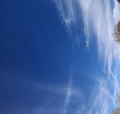 A row of houses with a blue sky and clouds above them.