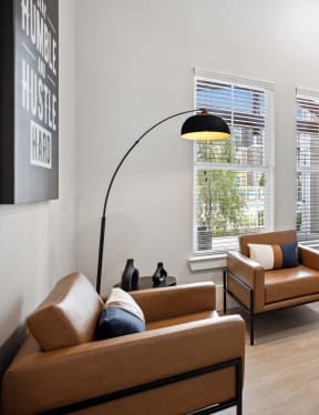 a living room with couches and chairs and a desk with a computer and monitor