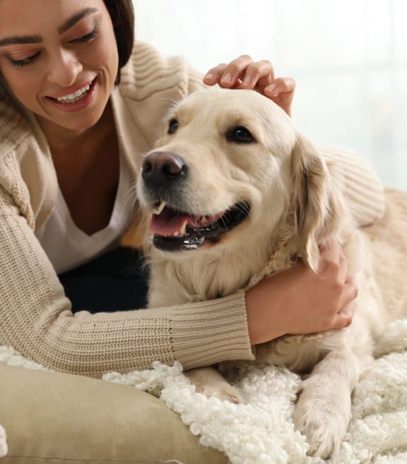 a woman is petting her dog on a couch